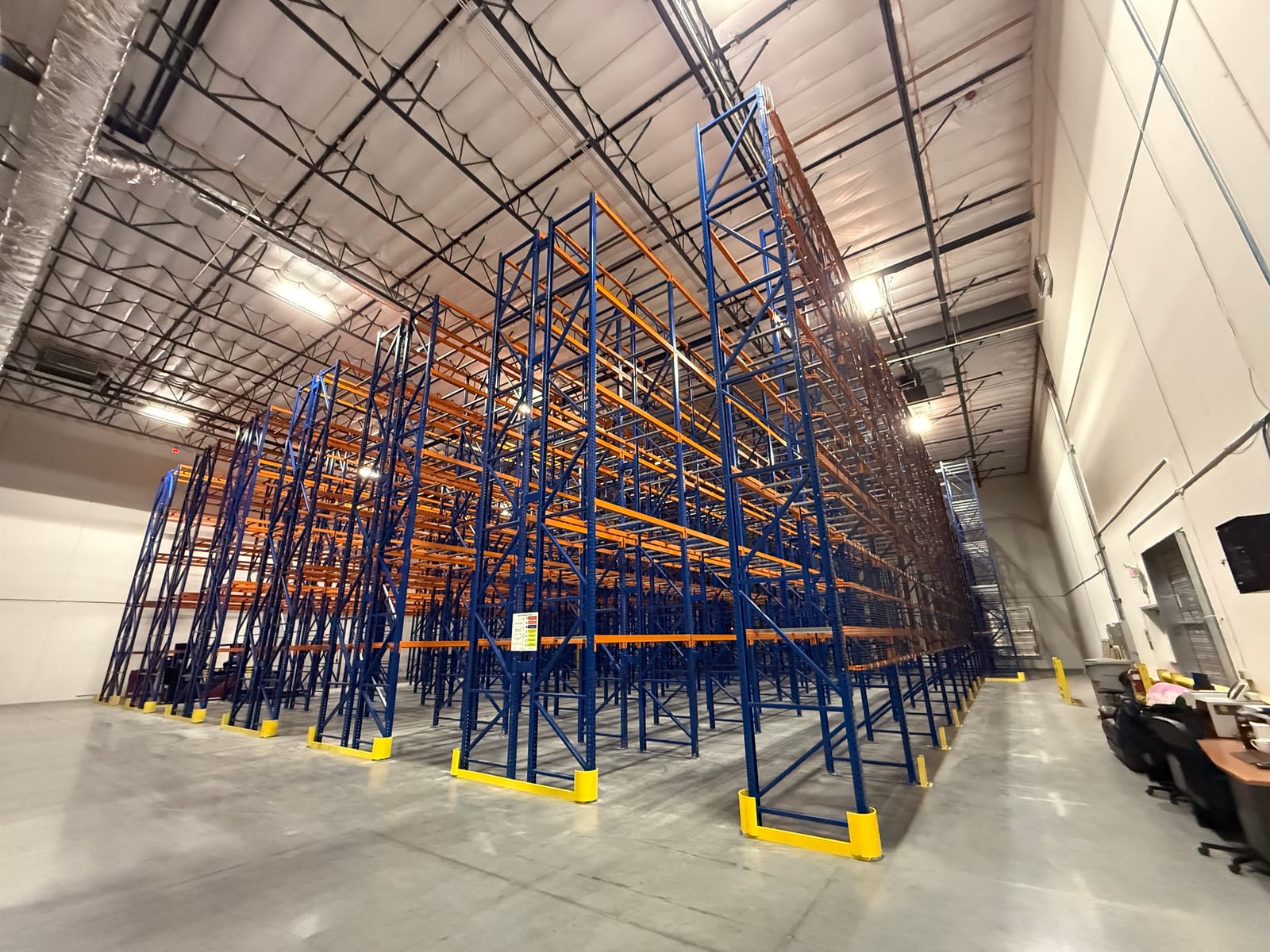Tall block of newly installed pallet racking with column protectors at each row end